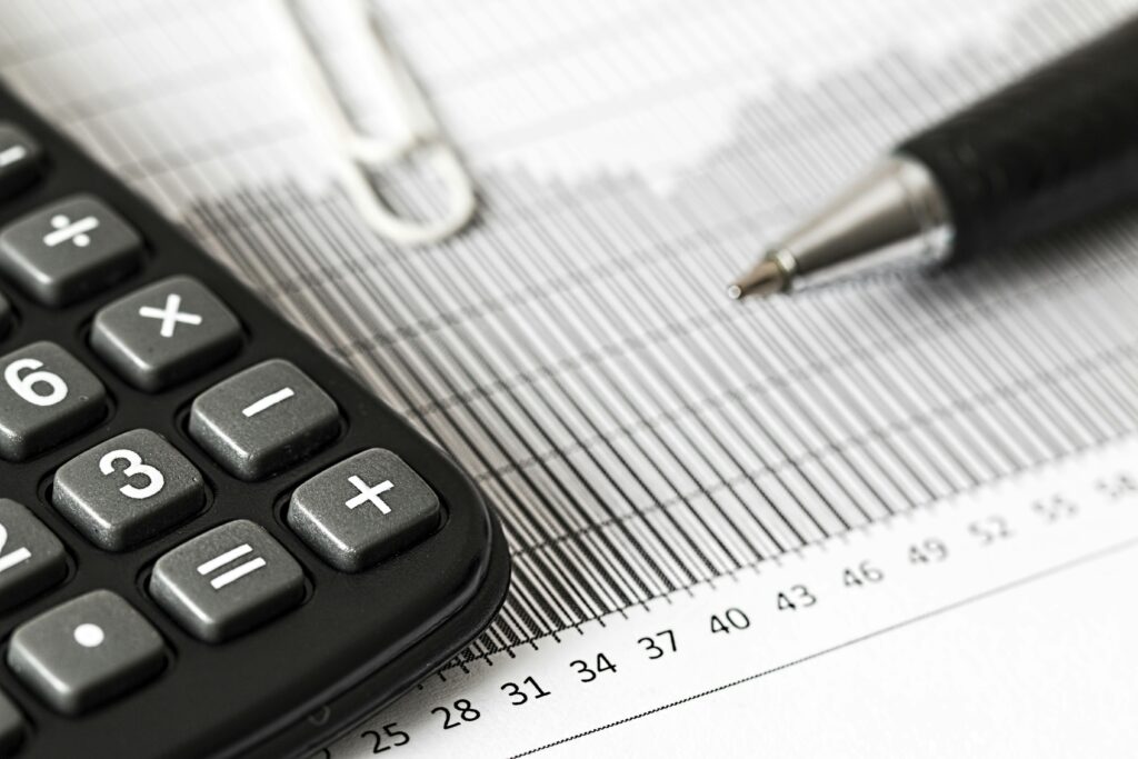 A close up image of a calculator and spreadsheet. It looks like they are doing their taxes.